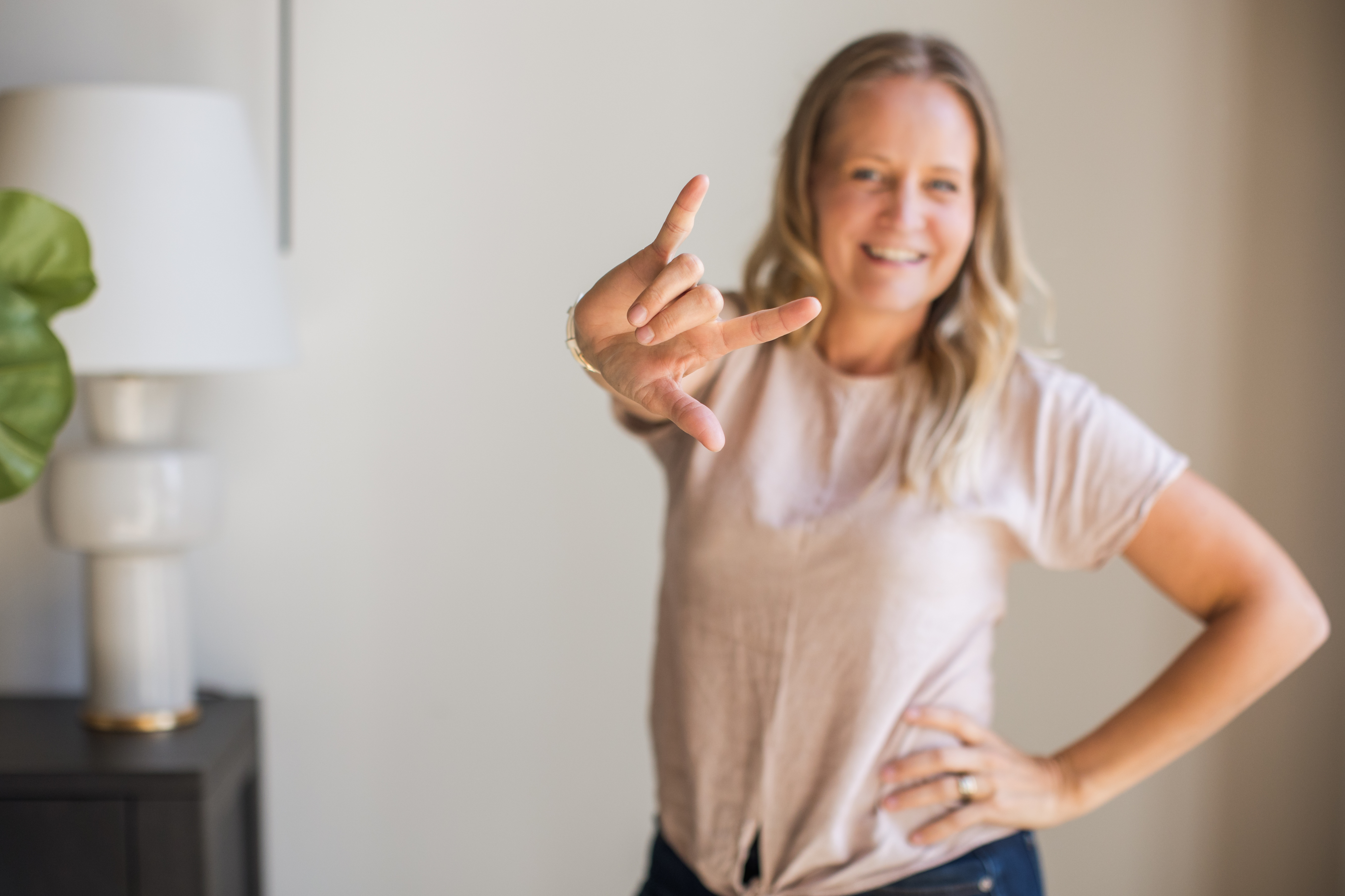 Toni Schafer signing I Love You in American Sign Language, representing the mission at the heart of TCS Real Estate International